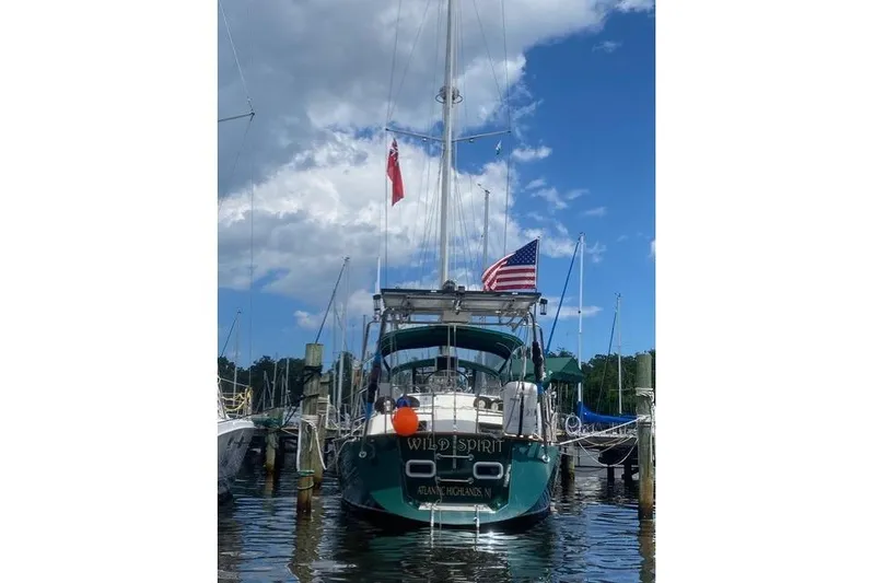 Wild Spirit Yacht Photos Pics Sailboat "Wild Spirit" docked, displaying American and red flags, under a partly cloudy sky.