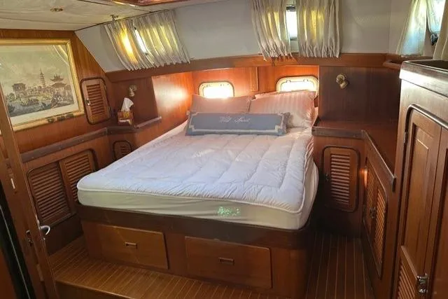 Wild Spirit Yacht Photos Pics Luxurious cabin interior of a 1999 Passport 456 yacht with a cozy bed and wooden decor.