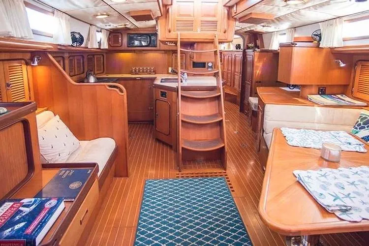 Wild Spirit Yacht Photos Pics Luxurious wooden interior of a 1999 Passport 456 yacht, featuring a cozy living area and kitchen.