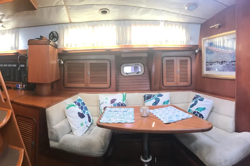 Wild Spirit Yacht Photos Pics Cozy yacht interior with wooden furnishings, cushioned seating, and nautical-themed decor.