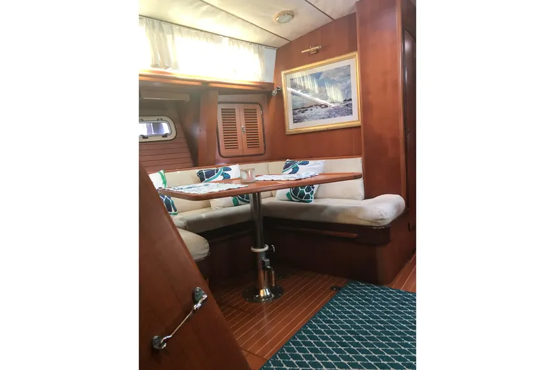 Wild Spirit Yacht Photos Pics Cozy interior of 1999 Passport 456 yacht with wooden furnishings and cushioned seating.