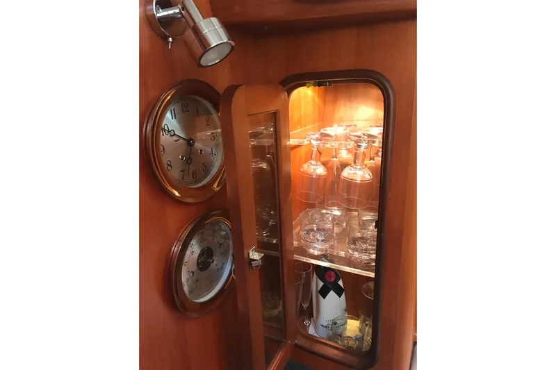 Wild Spirit Yacht Photos Pics Wooden cabinet with glassware, clock, and barometer on a Passport 456, 1999 model.