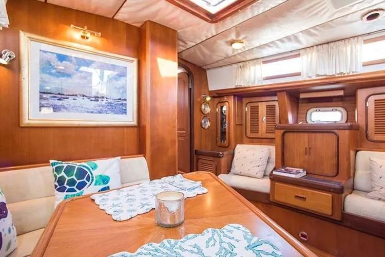 Wild Spirit Yacht Photos Pics Luxurious interior of a 1999 Passport 456 yacht with elegant wood finishes and cozy seating.