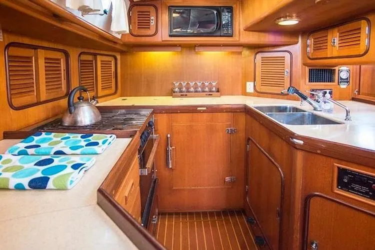 Wild Spirit Yacht Photos Pics Cozy wooden yacht kitchen with stove, sink, and microwave, Passport 456, 1999 model.