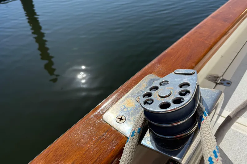 Wild Spirit Yacht Photos Pics Sailboat deck with winch and rope, reflecting sunlight on water. Passport 456, 1999 model.
