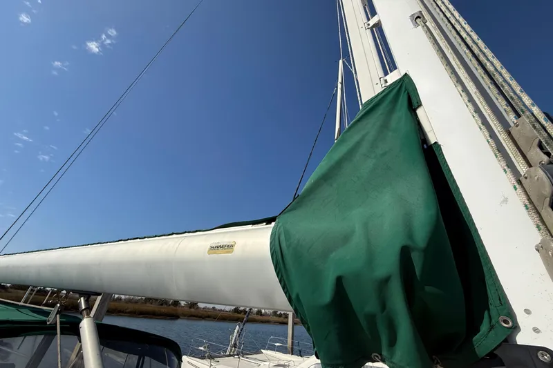 Wild Spirit Yacht Photos Pics Sailboat mast with green sail cover under clear blue sky, Passport 456, 1999 model.