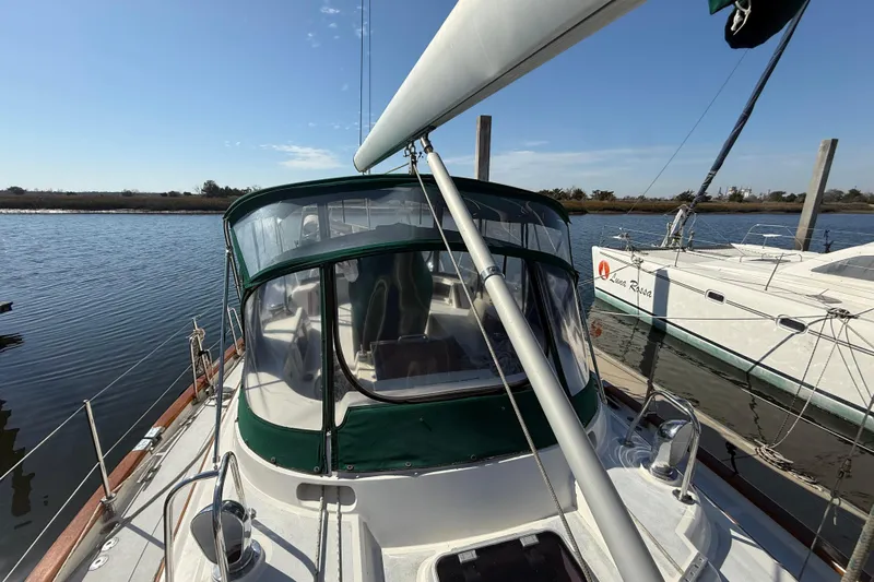 Wild Spirit Yacht Photos Pics Sailboat docked on calm water, featuring a green canopy, Passport 456, 1999 model.