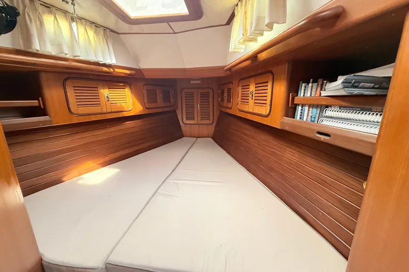 Wild Spirit Yacht Photos Pics Cozy wooden cabin interior of a 1999 Passport 456 yacht with books and natural light.