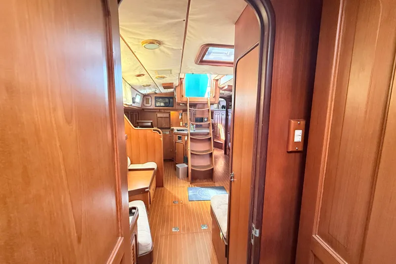 Wild Spirit Yacht Photos Pics Interior of a 1999 Passport 456 yacht, featuring wooden finishes and cozy seating.