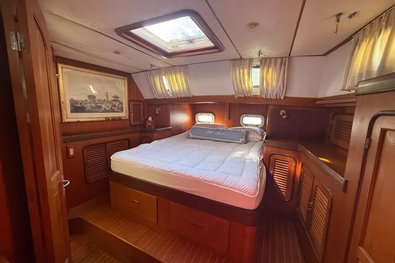 Wild Spirit Yacht Photos Pics Luxurious 1999 Passport 456 yacht cabin with cozy bed and elegant wood paneling.