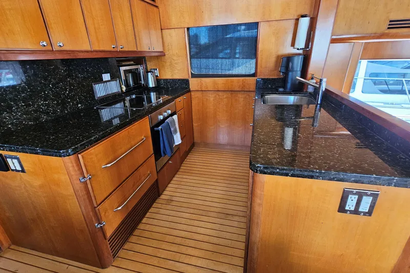 Katula Yacht Photos Pics Luxurious yacht kitchen with wooden cabinets and black granite countertops, Mikelson Long Range Cockpit MY 2003.