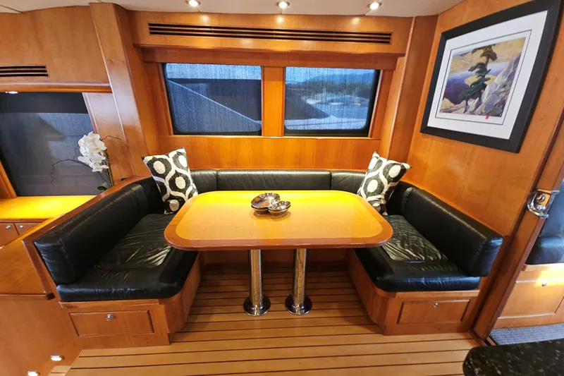 Katula Yacht Photos Pics Luxurious 2003 Mikelson yacht interior with wooden dining area and black leather seating.