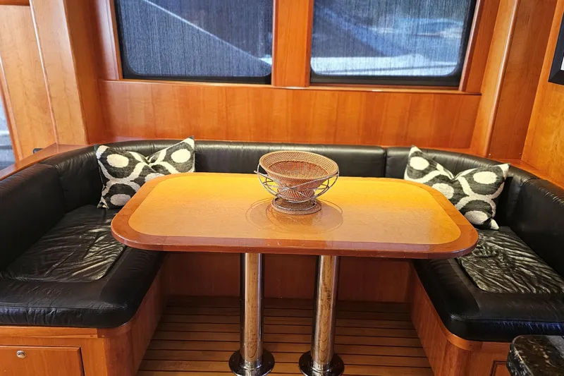 Katula Yacht Photos Pics Luxurious 2003 Mikelson Long Range Cockpit MY interior with leather seating and wooden table.