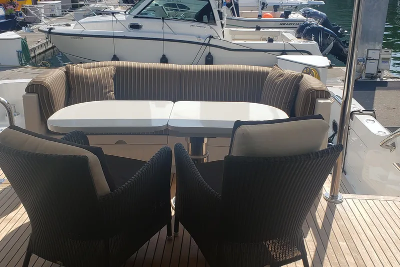 Katula Yacht Photos Pics Luxury seating area on 2003 Mikelson Long Range Cockpit MY yacht, docked at marina.