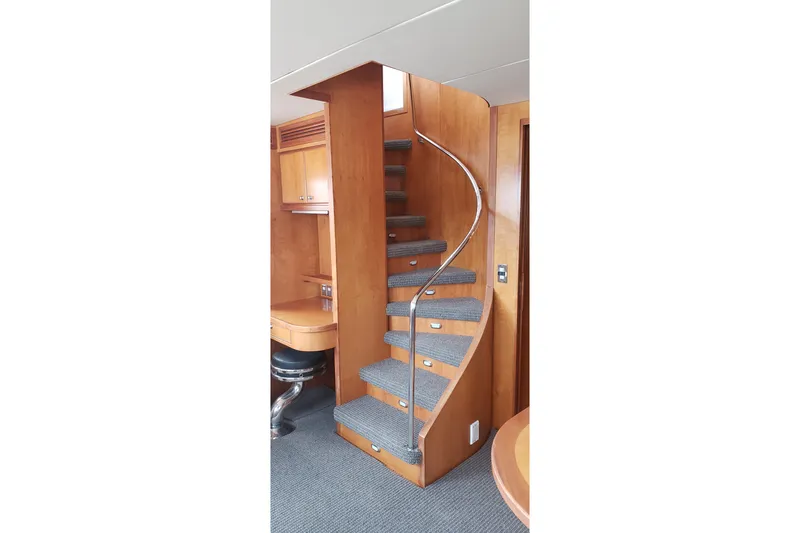 Katula Yacht Photos Pics Curved wooden staircase with carpeted steps in 2003 Mikelson Long Range Cockpit MY yacht.