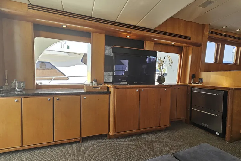 Katula Yacht Photos Pics Luxurious interior of 2003 Mikelson Long Range Cockpit MY yacht with wood cabinetry and modern appliances.