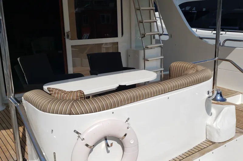 Katula Yacht Photos Pics 2003 Mikelson Long Range Cockpit MY yacht with striped seating and table on deck.