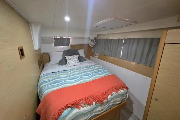 Tetelestai Yacht Photos Pics Cozy bedroom in 2011 Lagoon 400 catamaran with colorful bedding and nautical decor.