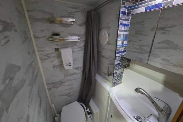 Tetelestai Yacht Photos Pics Compact bathroom in a 2011 Lagoon 400 yacht with modern fixtures and blue tile accents.
