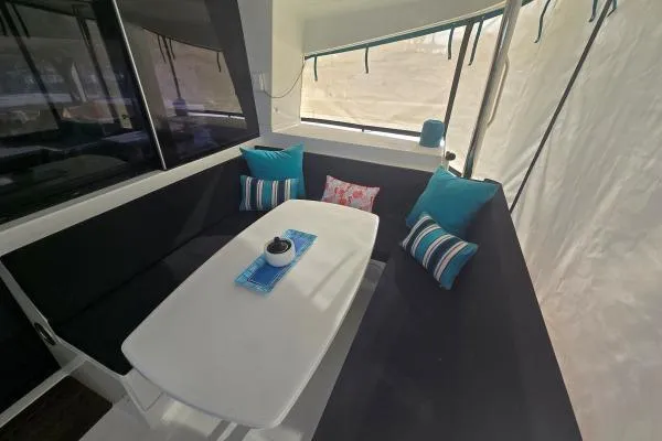 Tetelestai Yacht Photos Pics Cozy seating area on 2011 Lagoon 400 catamaran with colorful cushions and table.