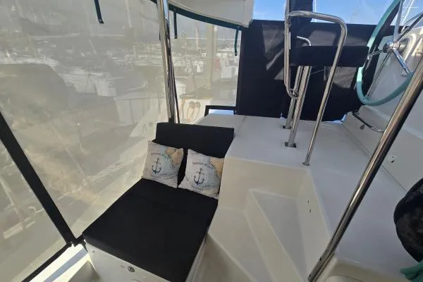 Tetelestai Yacht Photos Pics Lagoon 400 catamaran cockpit with black seating and nautical-themed cushions, 2011 model.