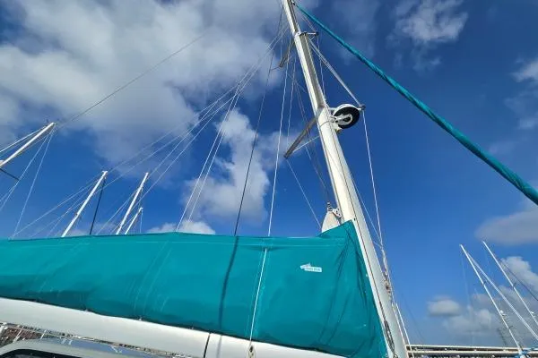 Tetelestai Yacht Photos Pics Sailboat mast and sail of 2011 Lagoon 400 against a blue sky with clouds.