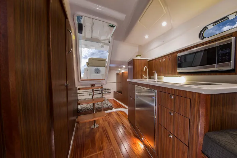  Yacht Photos Pics Manufacturer Provided Image: 2017 Pursuit OS 355 Offshore yacht interior with modern kitchen and cozy sleeping area.