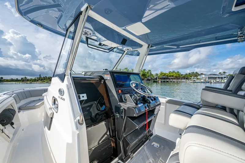 Island Girl II Yacht Photos Pics 2023 Pursuit S 358 Sport boat interior with helm, seats, and waterfront view.