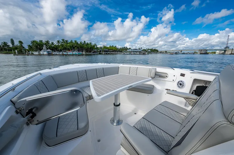 Island Girl II Yacht Photos Pics 2023 Pursuit S 358 Sport boat interior with seating and table, on a scenic waterway.