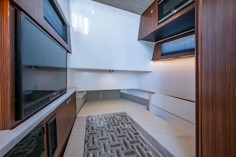 Island Girl II Yacht Photos Pics 2023 Pursuit S 358 Sport cabin interior with modern wood finishes and seating area.
