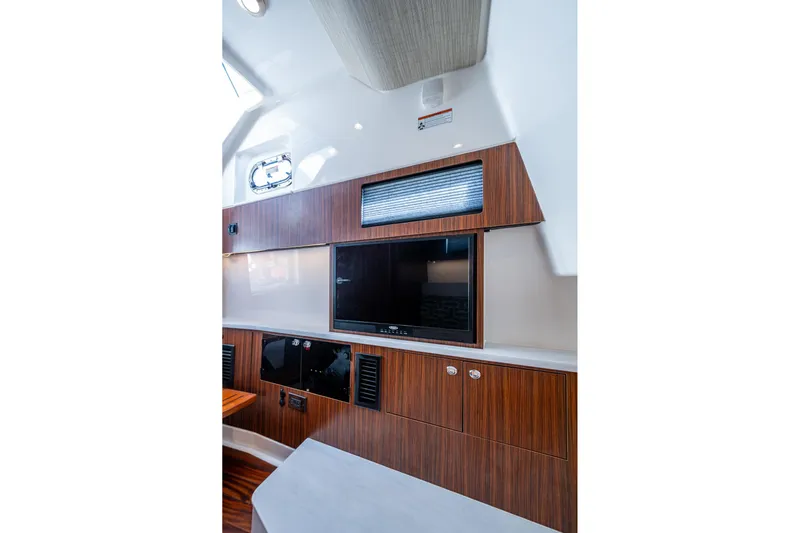 Island Girl II Yacht Photos Pics 2023 Pursuit S 358 Sport interior with wood paneling and built-in TV.