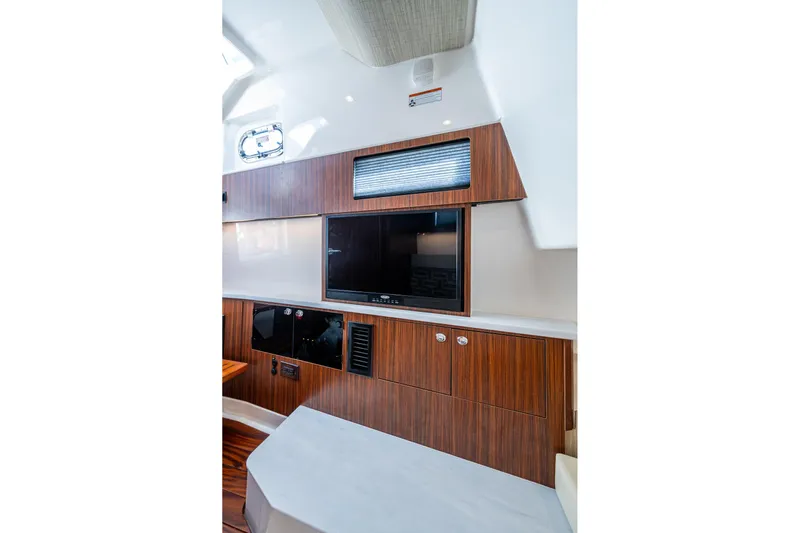 Island Girl II Yacht Photos Pics 2023 Pursuit S 358 Sport interior with wood paneling and mounted TV.