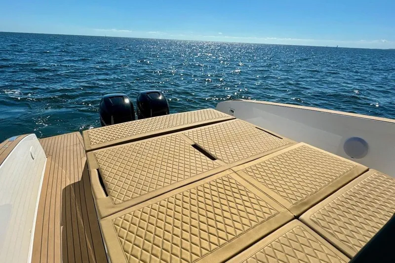  Yacht Photos Pics Luxury Tesoro T38 yacht deck with quilted seating, overlooking serene ocean waters, 2023 model.