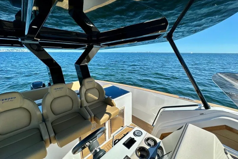  Yacht Photos Pics 2023 Tesoro T38 boat interior with luxurious seating, steering console, and ocean view.