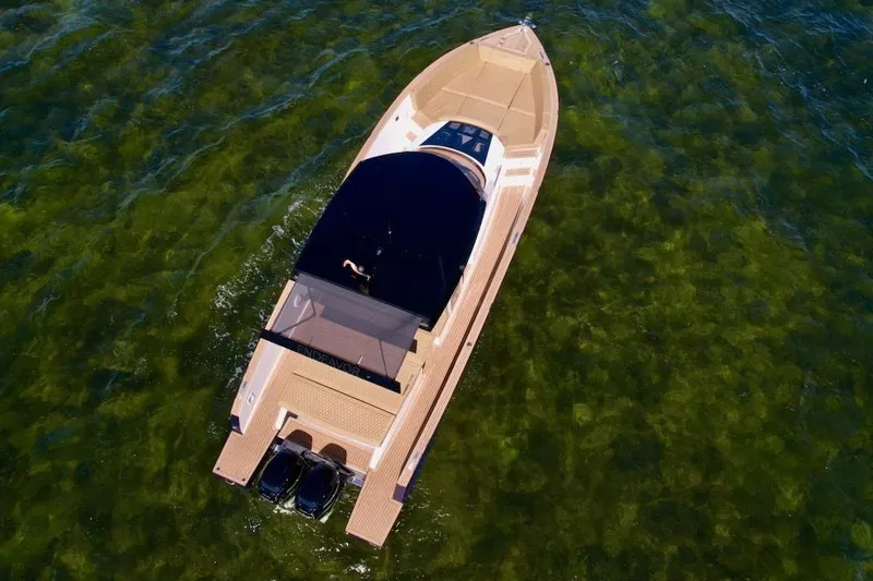  Yacht Photos Pics Aerial view of 2023 Tesoro T38 boat cruising on clear green water.