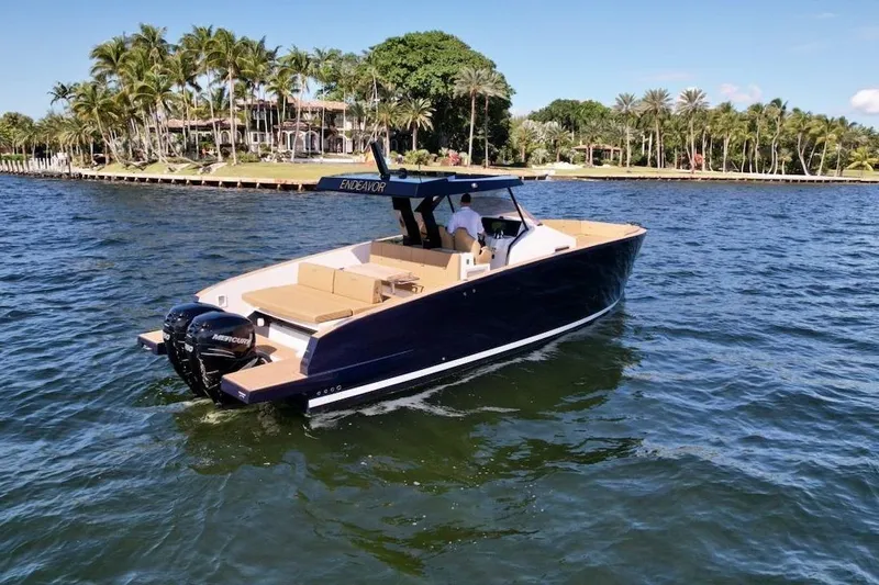  Yacht Photos Pics 2023 Tesoro T38 boat cruising on a sunny day near a tropical shoreline.