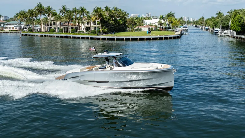  Yacht Photos Pics 2025 Solaris Power 44 Open yacht cruising on a scenic waterway with palm trees.