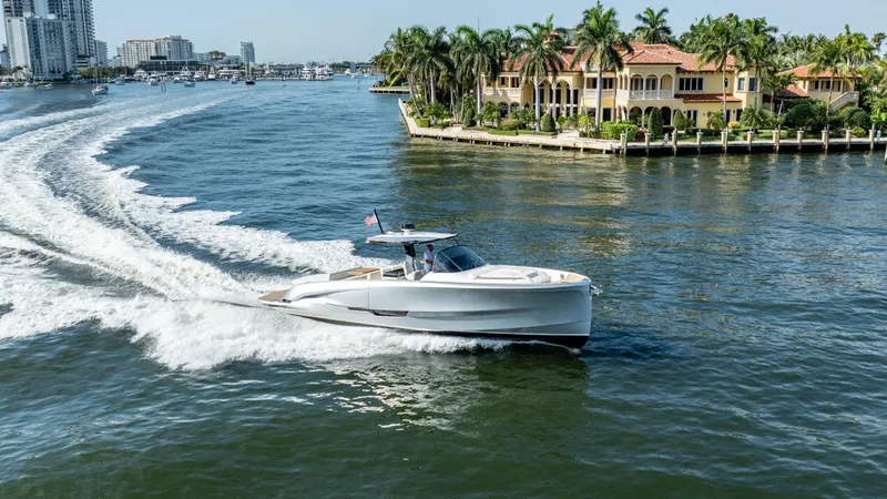  Yacht Photos Pics 2025 Solaris Power 44 Open yacht cruising near luxury waterfront homes.