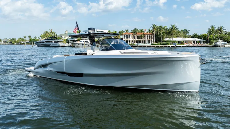  Yacht Photos Pics 2025 Solaris Power 44 Open yacht cruising on a sunny day, with waterfront homes in the background.