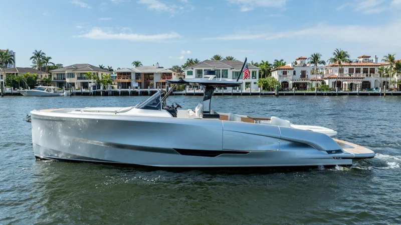  Yacht Photos Pics 2025 Solaris Power 44 Open yacht cruising on a sunny day near waterfront homes.