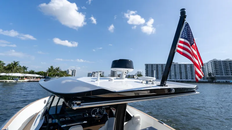  Yacht Photos Pics 2025 Solaris Power 44 Open yacht with American flag, cruising near waterfront buildings.