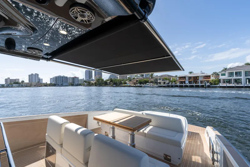  Yacht Photos Pics 2025 Solaris Power 44 Open yacht with luxurious seating, cruising on a scenic waterfront.