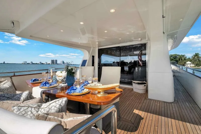 Boulos Yacht Photos Pics Luxurious Gianetti 86 yacht deck with elegant dining setup, ocean view, and city skyline.