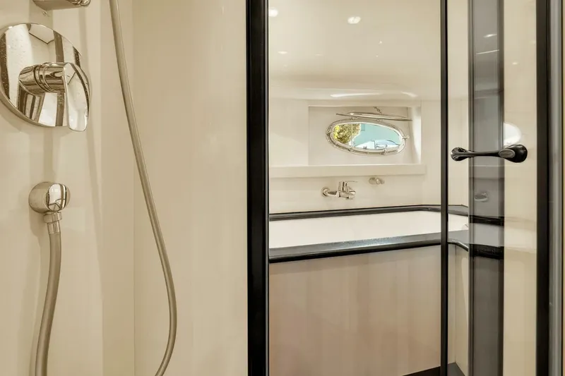 Boulos Yacht Photos Pics Luxurious bathroom interior on 2003 Gianetti 86 yacht with modern fixtures and porthole window.