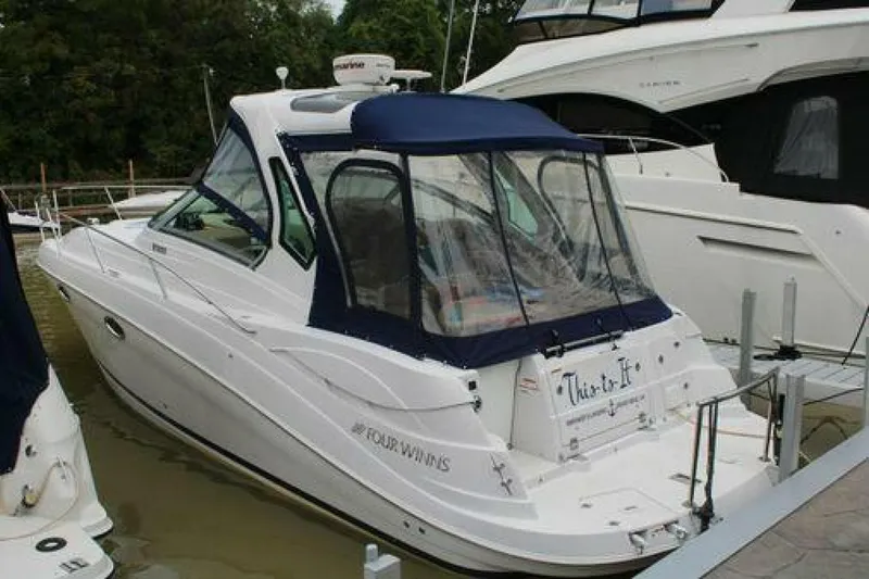  Yacht Photos Pics 2011 Four Winns V335 boat docked, featuring a blue canopy and sleek white design.