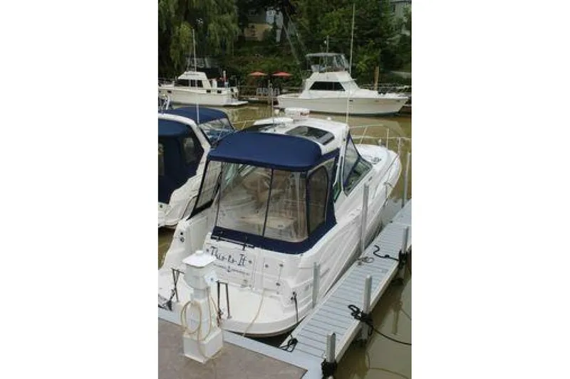  Yacht Photos Pics 2011 Four Winns V335 boat docked with blue canopy, surrounded by other boats.