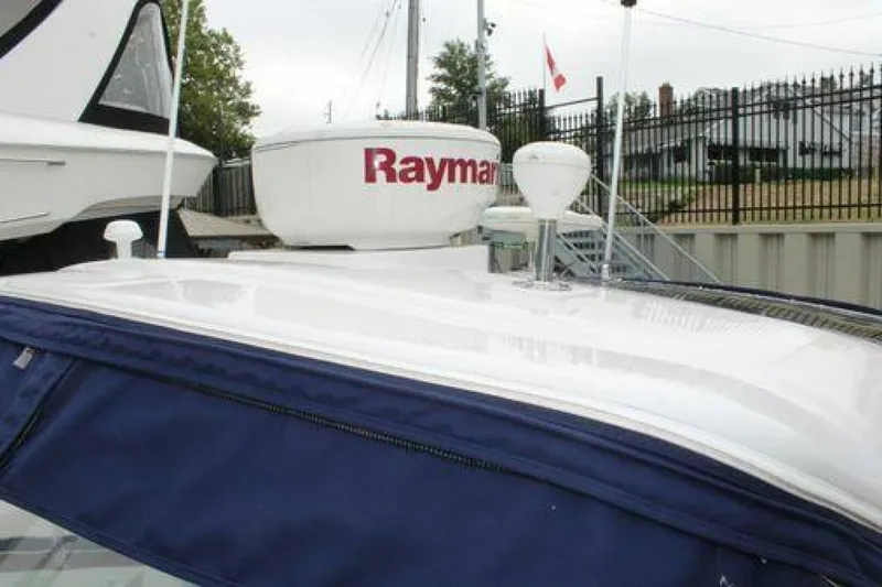  Yacht Photos Pics 2011 Four Winns V335 boat with Raymarine radar, docked near a fence.