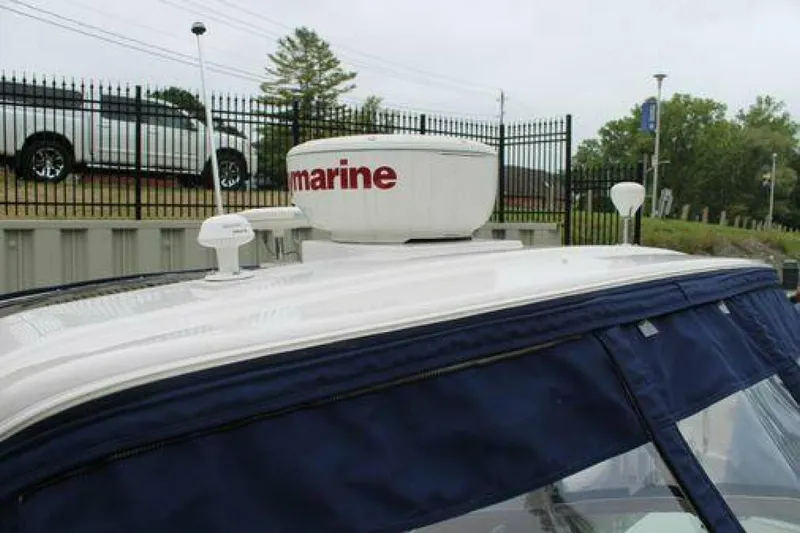  Yacht Photos Pics 2011 Four Winns V335 boat with radar equipment on top, parked near a fence.