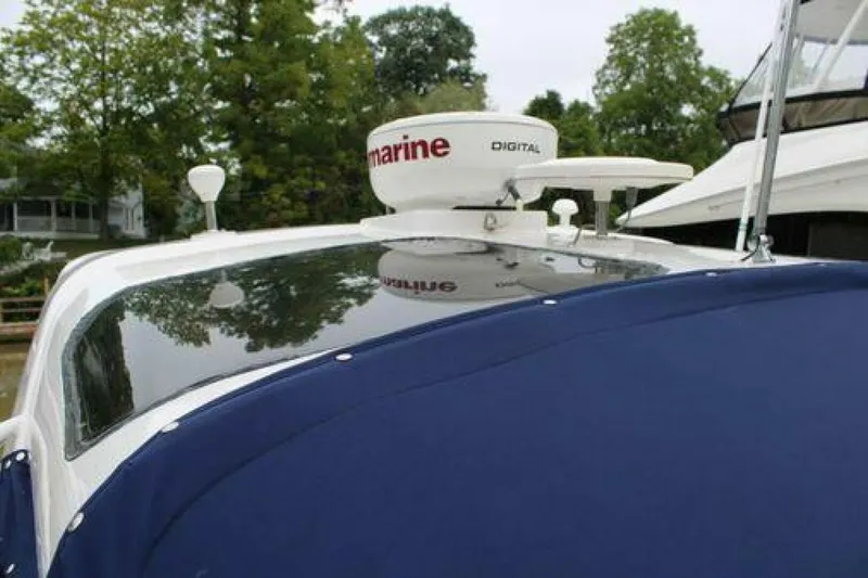  Yacht Photos Pics 2011 Four Winns V335 boat with radar equipment, docked near trees.