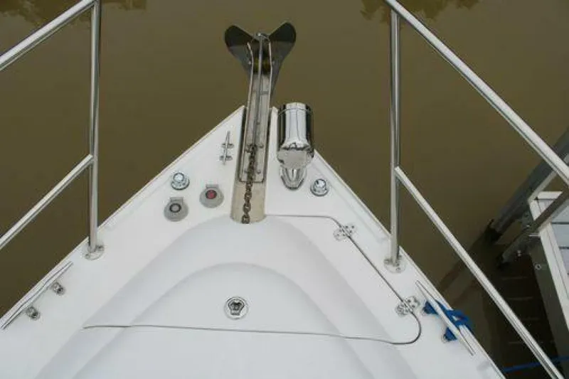  Yacht Photos Pics Bow of 2011 Four Winns V335 boat with anchor and railing, docked on calm water.